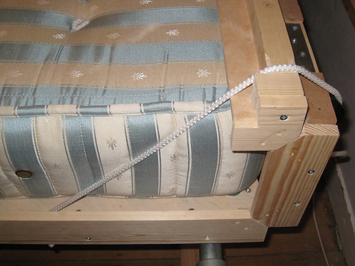 Rope replaces latches holding the head end of the wallbed round the mattress (prior to lifting)