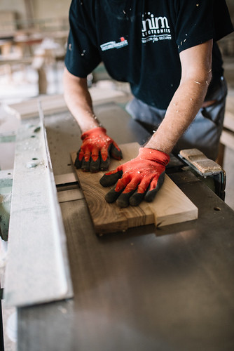 Experienced carpenter processing a piece of wood with a planer