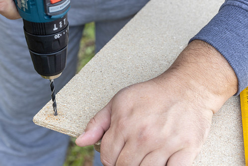 Woodworker drilling a hole on the plywood