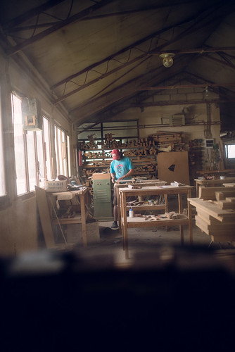 A young man working alone in a furniture workshop