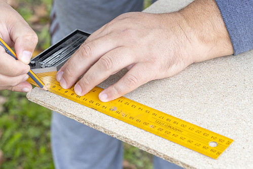 Woodworker taking measures on the plywood