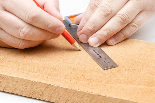 Measuring wooden board with measuring tool and pencil