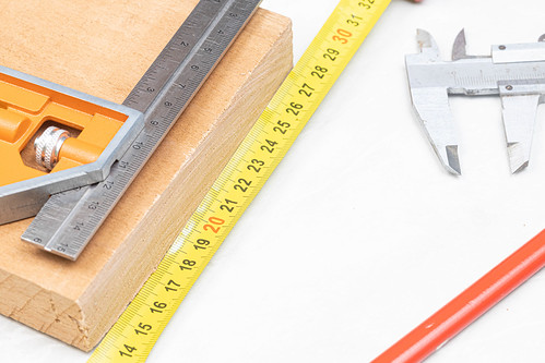 Measuring tools on the wooden board above white background