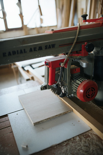 A piece of wood and a cutting machine in a carpenters workshop.