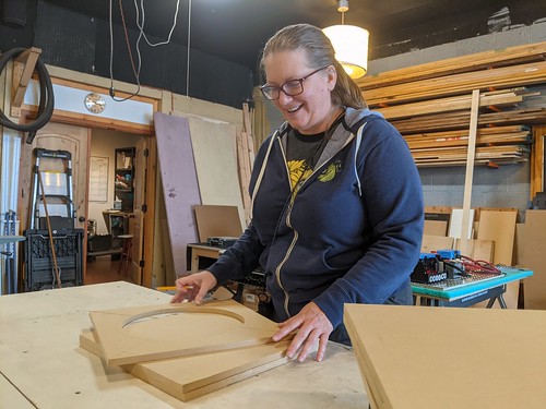 Woodworker smiling with a stack of project wood